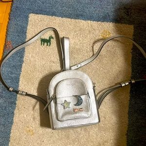 Henri Bendel.  Iconic NYC brand silver mini backpack with pins included.